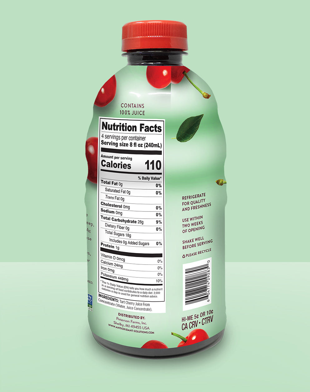 The back of a green bottle of tart cherry juice with a green background.